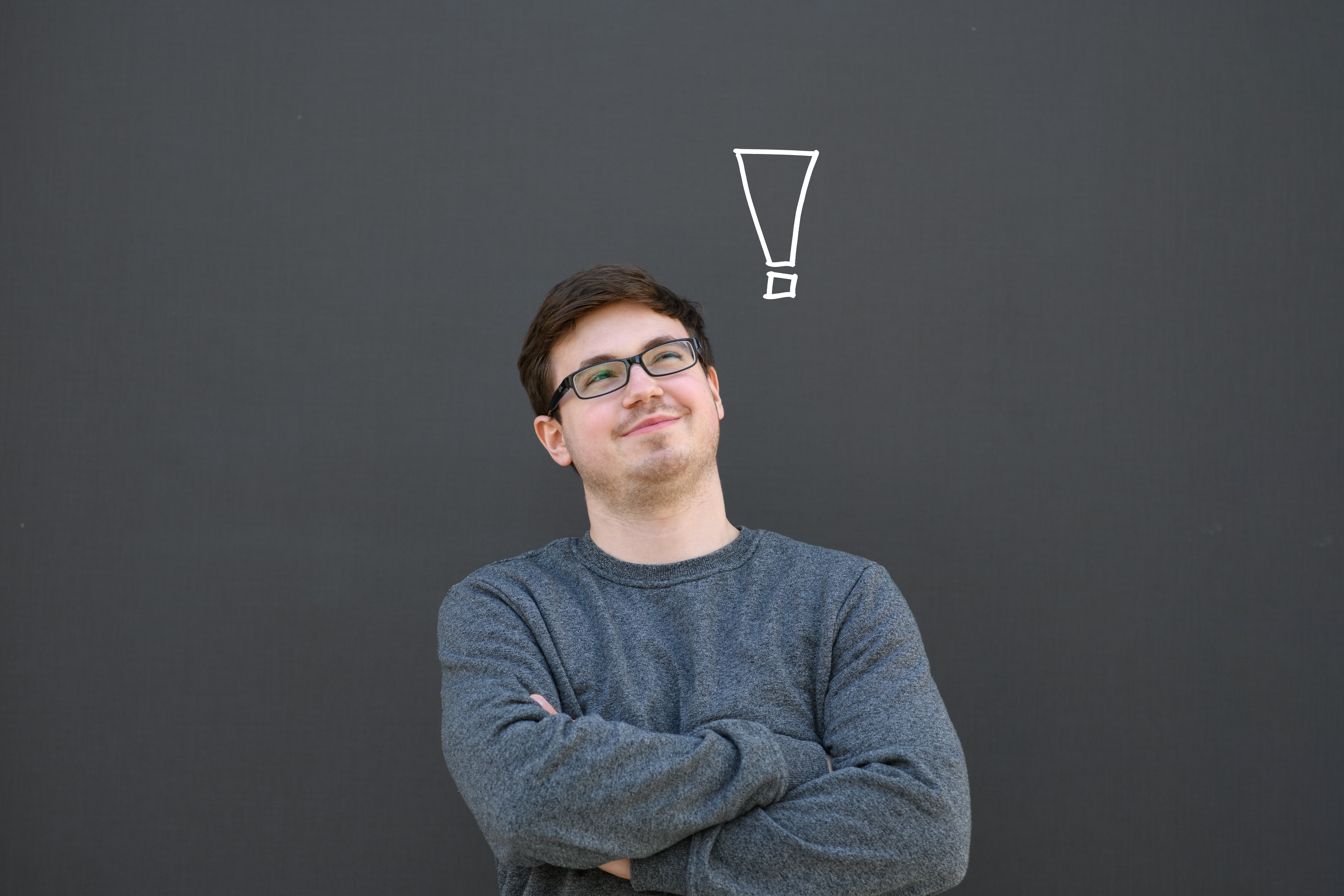 Ein Studierender blickt auf zu einem imaginierten weißen Ausrufezeichen.