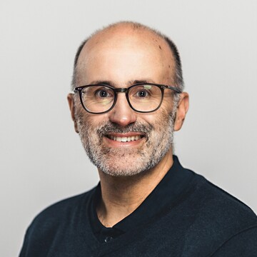 Jorge Murcia Serra hat kurzes graues Haar und einen Bart. Er trägt eine Brille, ein dunkelblaues Hemd und einen dunkelblauen Pullover.