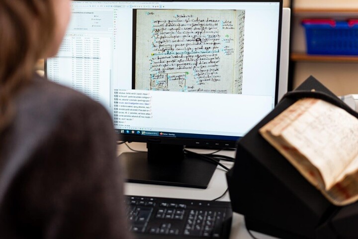 Eine Person sitzt vor einem Computermonitor und arbeitet mit einem Programm zur Texterkennung.