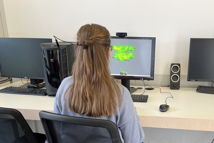 Eine Person sitzt an der Eye-Tracking-Station im ExpLAB im Bibliotheksbereich Schloss Schneckenhof.