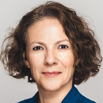 Elisabeth Wagner hat kinnlanges braunes Haar, sie trägt eine dunkelblaue Bluse.