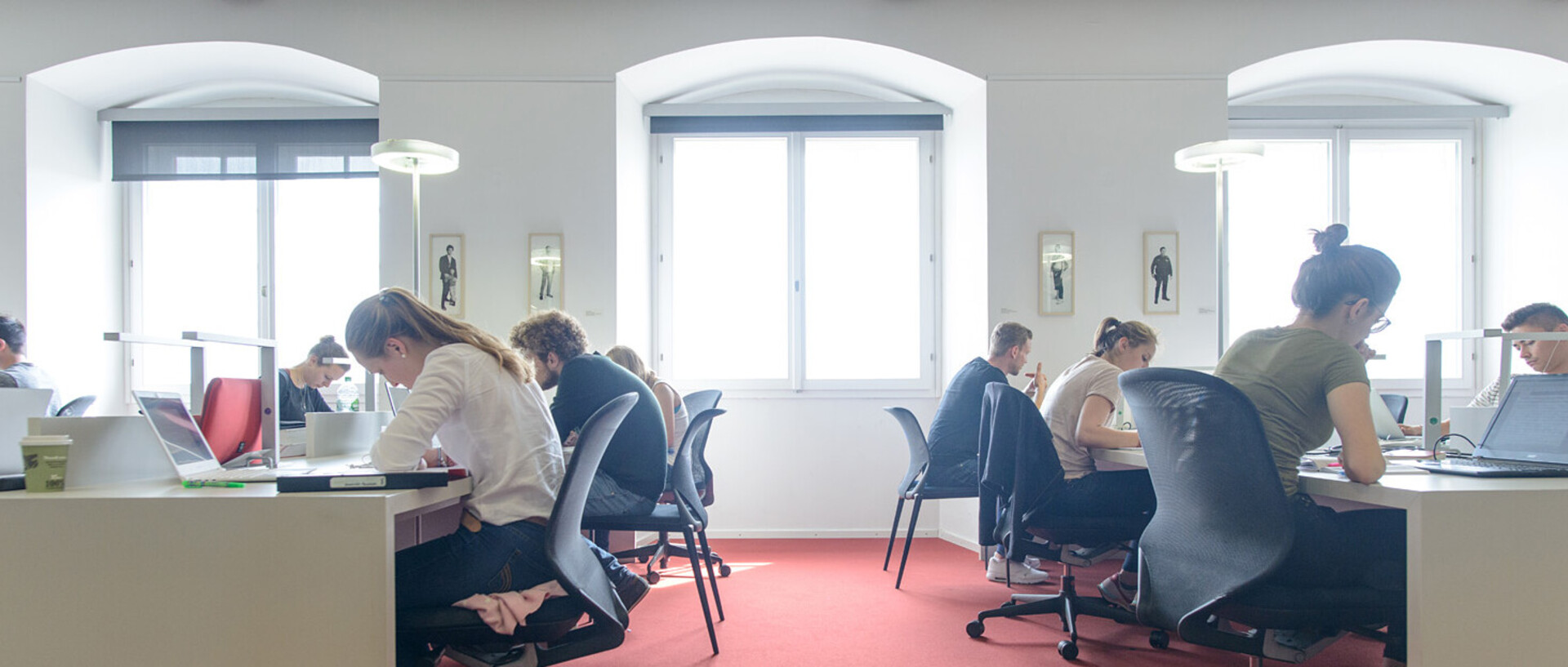 Studierende lernen an Arbeitsplätzen im Bibliotheksbereich Schloss Ehrenhof.