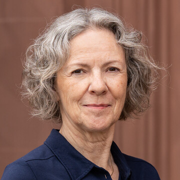 Elisabeth Wagner hat graues kinnlanges Haar. Sie trägt eine dunkelblaue Bluse.